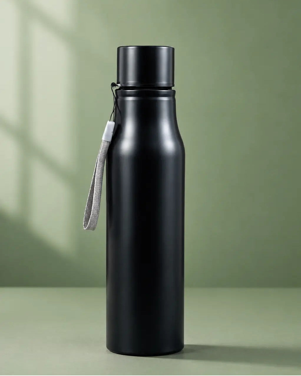 Black water bottle with a strap on a green background